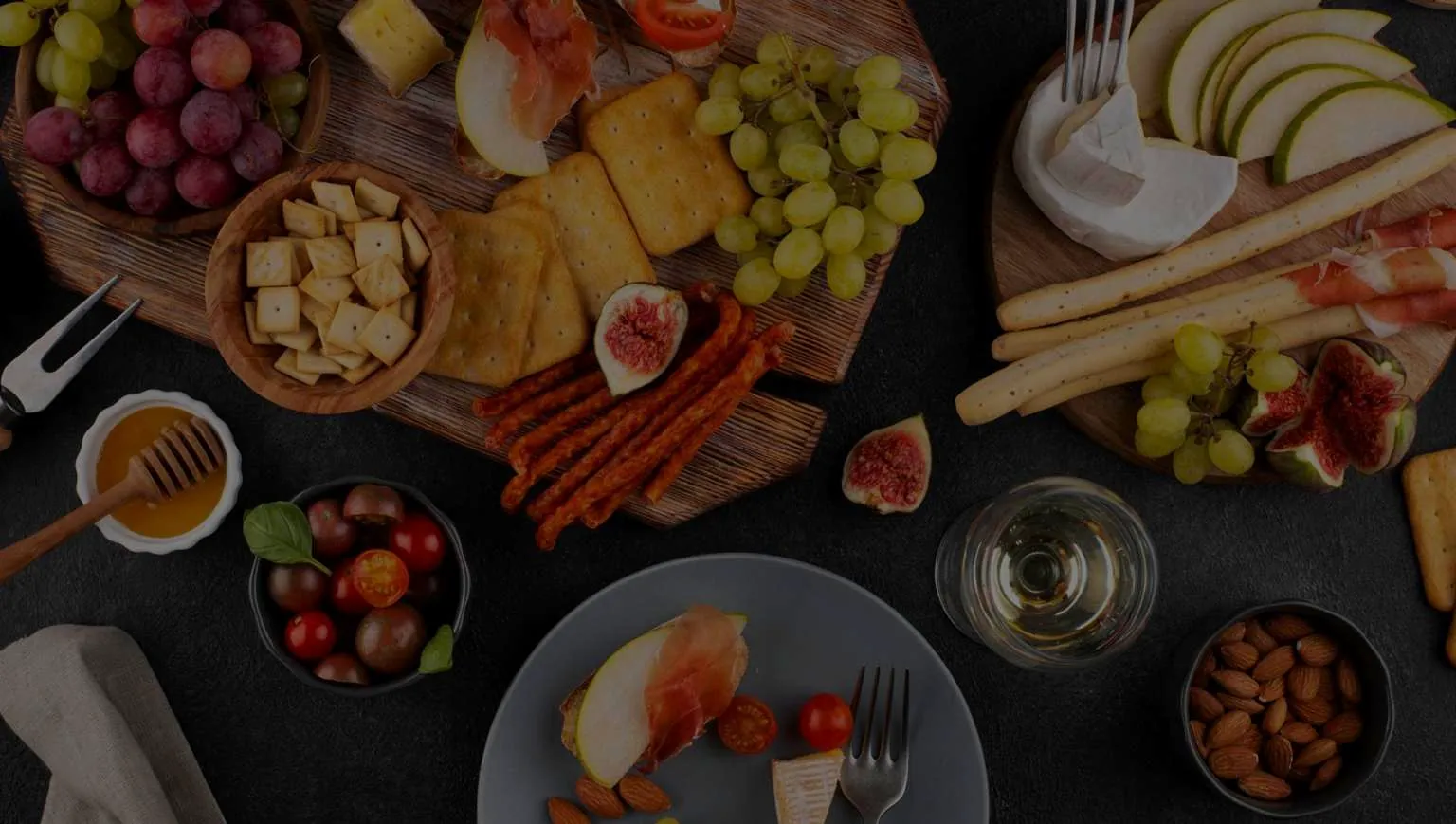A shared table of cheese, grapes, honey and bread